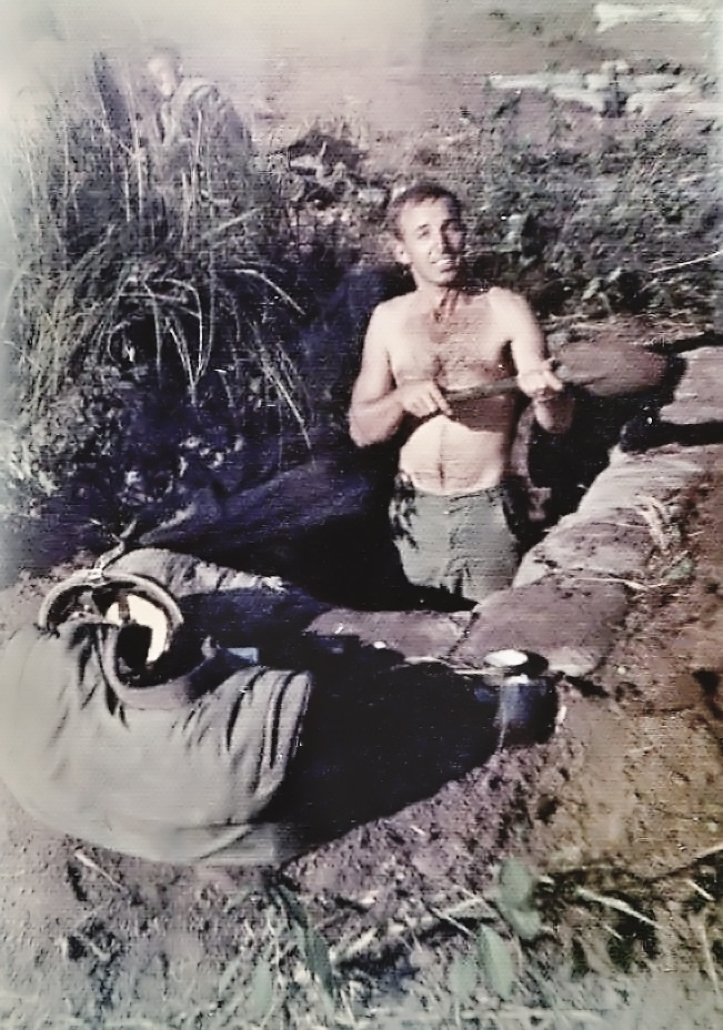 Derl Horn, shirtless, in a foxhole in Vietnam