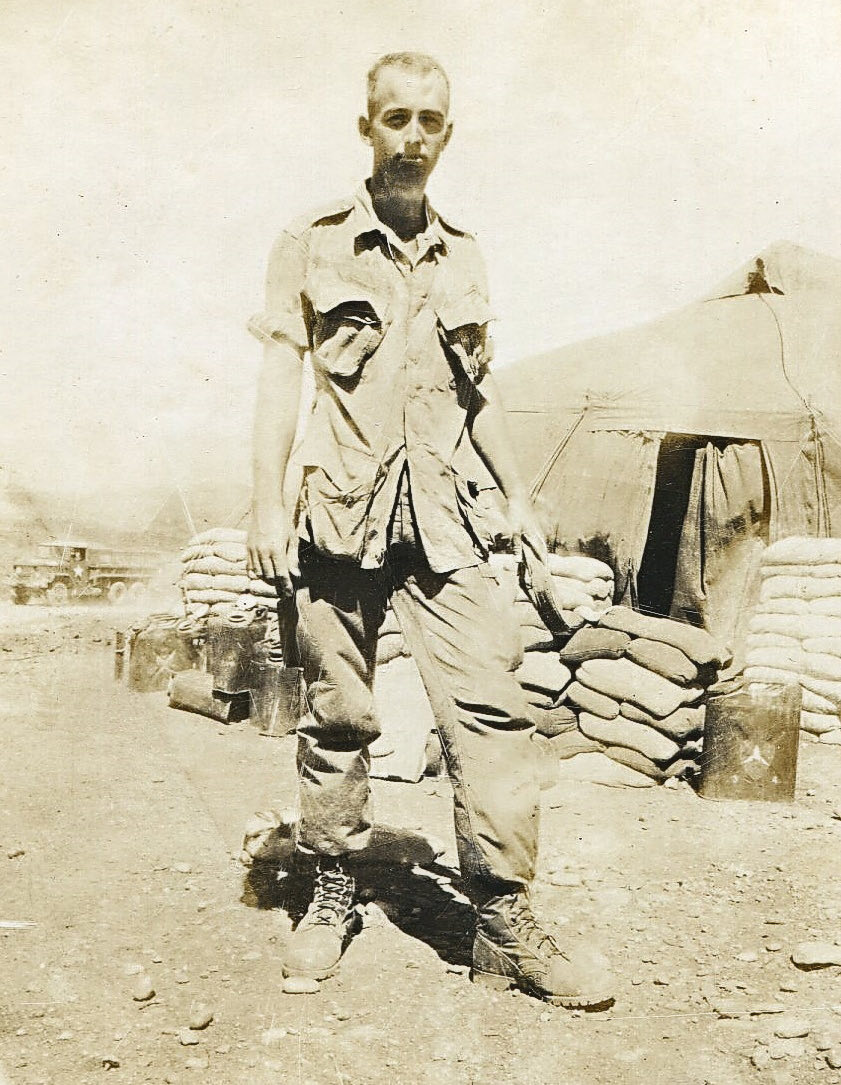 Derl Horn standing in a Vietnam base camp