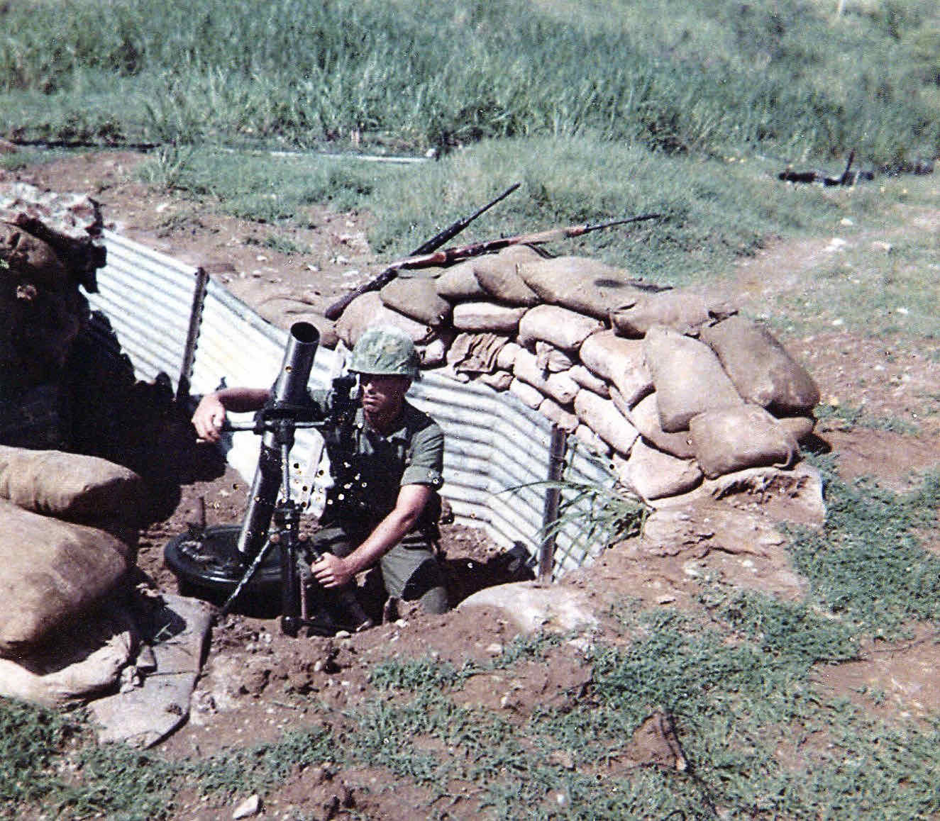 A Marine mortar position, weapons propped against sandbags