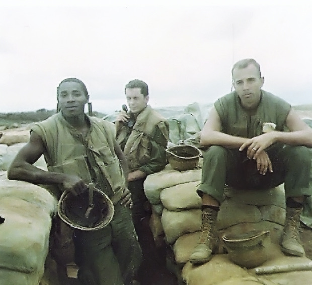 Three Marines seated on sandbags